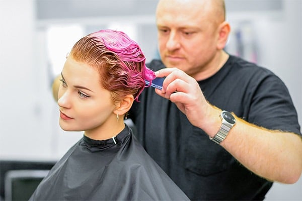 Парикмахер укладывает короткие волосы нового клиента
